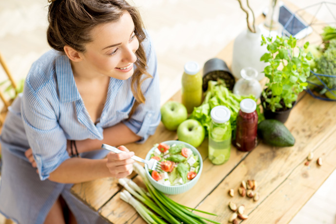 Mujer comiendo alimentos para fortalecer su sistema inmunológico.