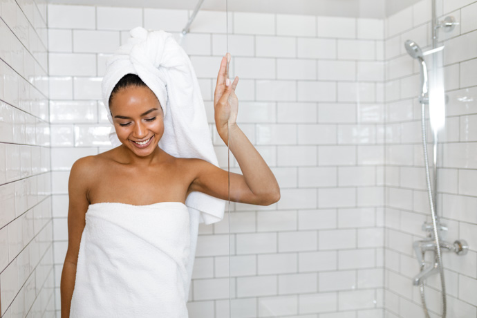 mujer con toallas saliendo de la ducha