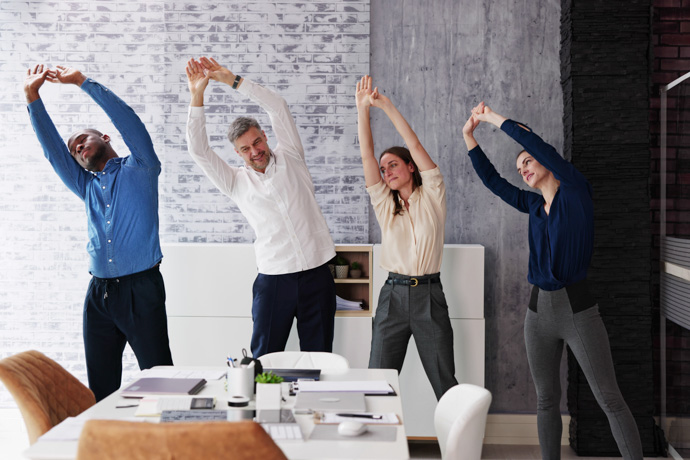 grupo de personas haciendo estiramientos en oficina