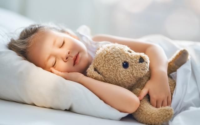 Niña durmiendo con su osito de peluche