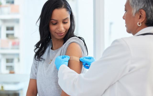 Sanitario a punto de poner una vacuna en el brazo de una chica