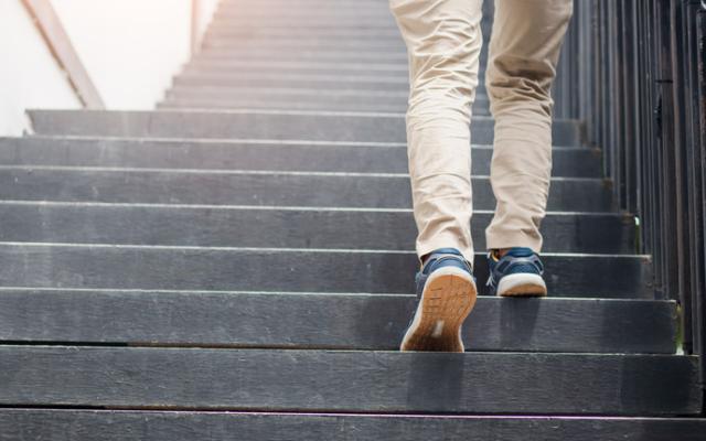 Piernas de un hombre subiendo escaleras