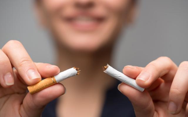 Mujer rompiendo un cigarro.