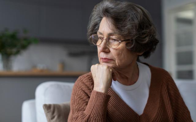 Mujer mayor reflexionando sobre cómo prevenir el Alzheimer.