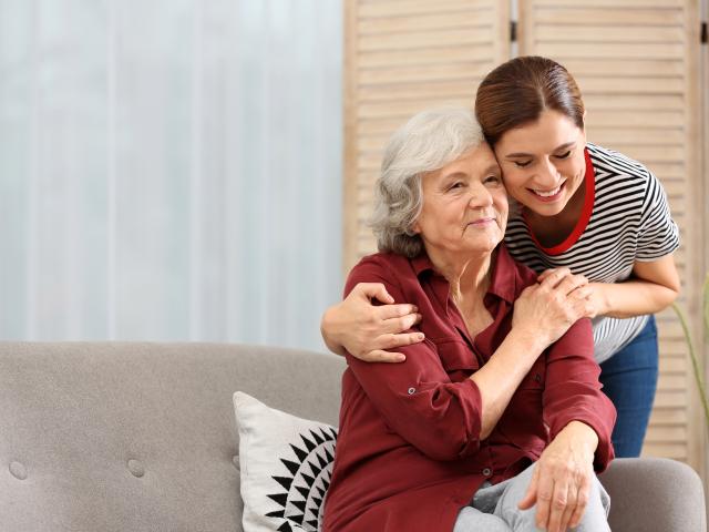 Mujer abrazada a su madre con Alzheimer.