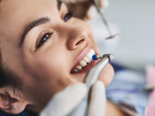 Mujer haciéndose una limpieza dental.