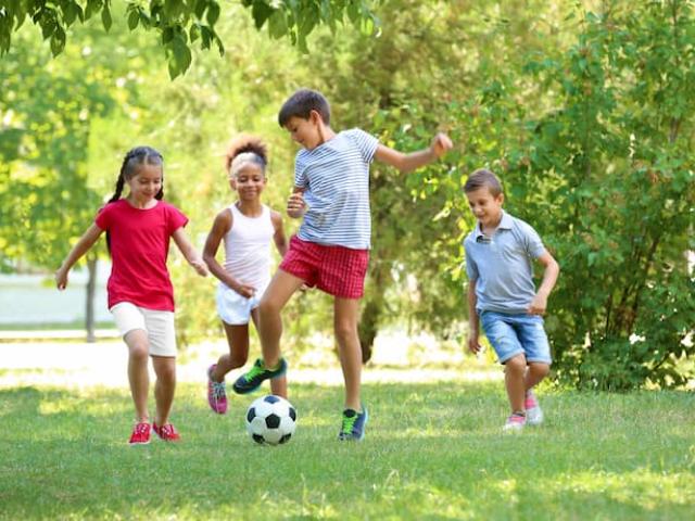 niños jugando fútbol al aire libre