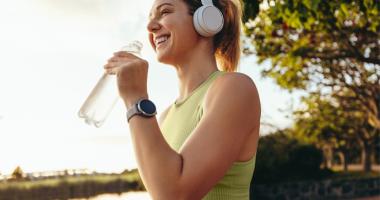 Mujer tomando agua ddurante una caminata 